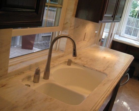 A kitchen sink with a faucet and a window