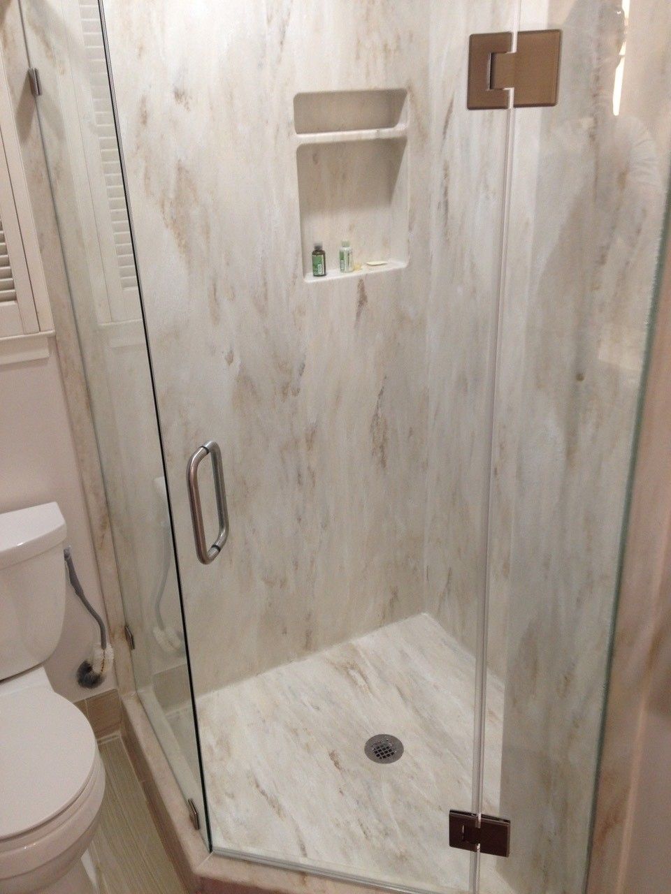 A bathroom with a toilet and a shower with a glass door