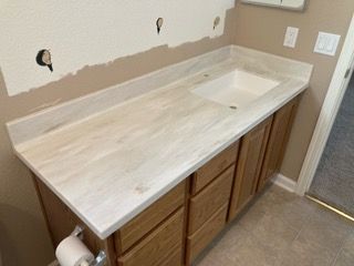 A bathroom vanity with a sink and wooden cabinets.