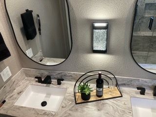 A bathroom with two sinks and two mirrors.