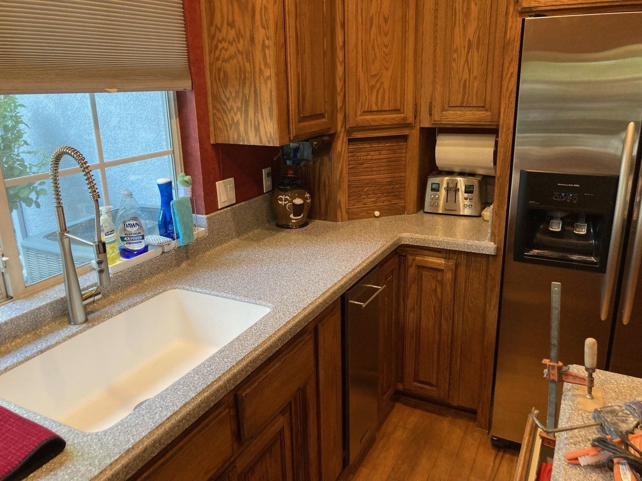 A kitchen with a sink , refrigerator , and dishwasher.