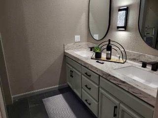 A bathroom with two sinks and two mirrors.