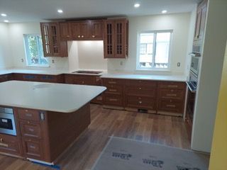 A kitchen with wooden cabinets and white counter tops