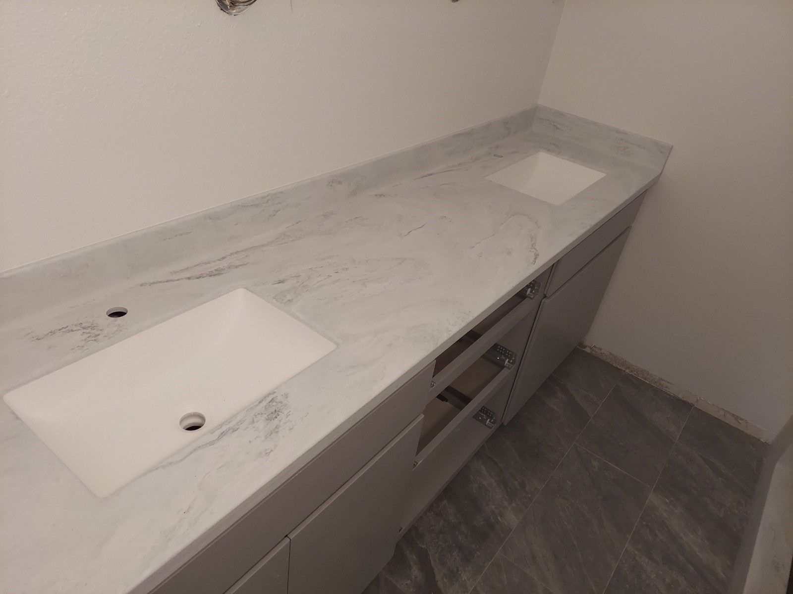 A bathroom with two sinks and a white counter top.