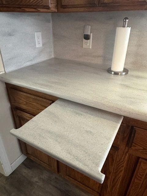 A kitchen counter with a paper towel holder on it.