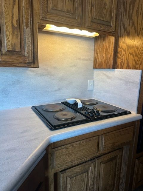 A kitchen with a stove top oven and wooden cabinets
