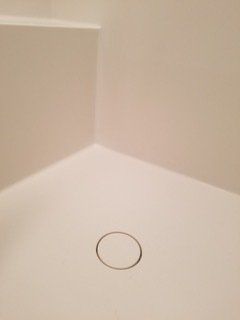 A white bathroom sink with a drain hole in the corner.