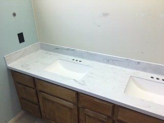 A bathroom vanity with two sinks and wooden cabinets.