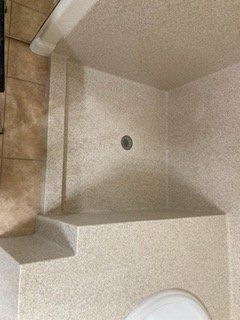 A bathroom with a shower stall and a toilet.