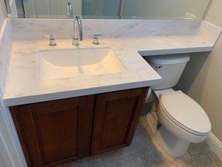 A bathroom with a sink , toilet and mirror.