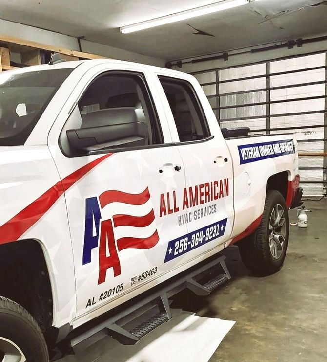A white all american truck is parked in a garage