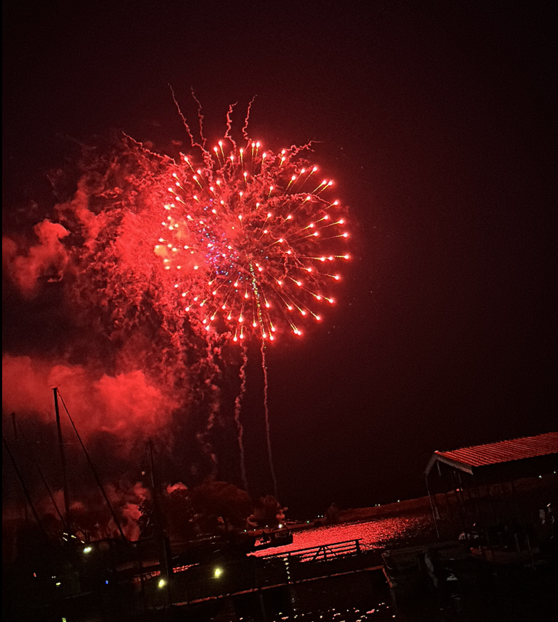 A large red fireworks display in the night sky