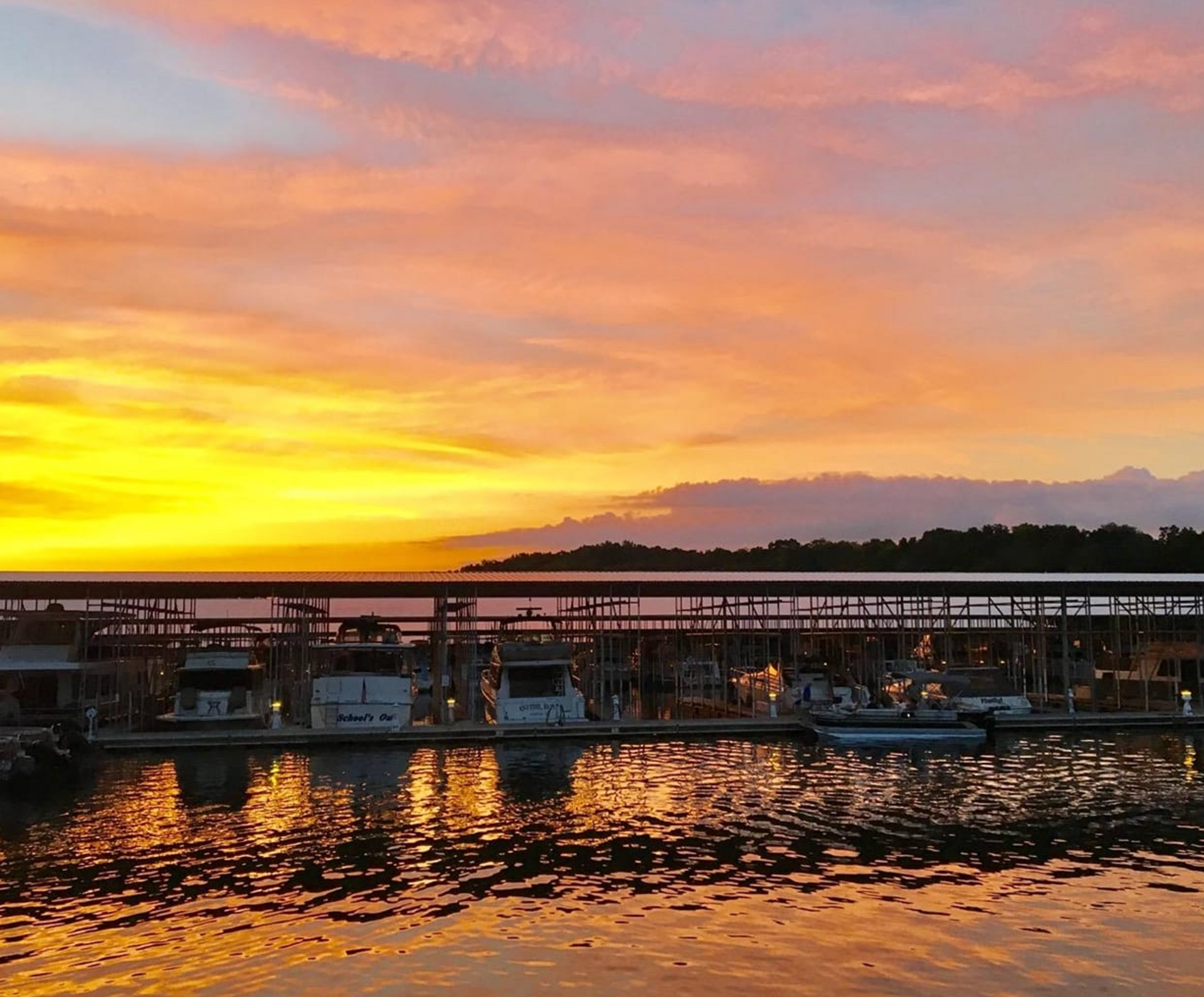 A sunset over a body of water with a dock in the foreground.