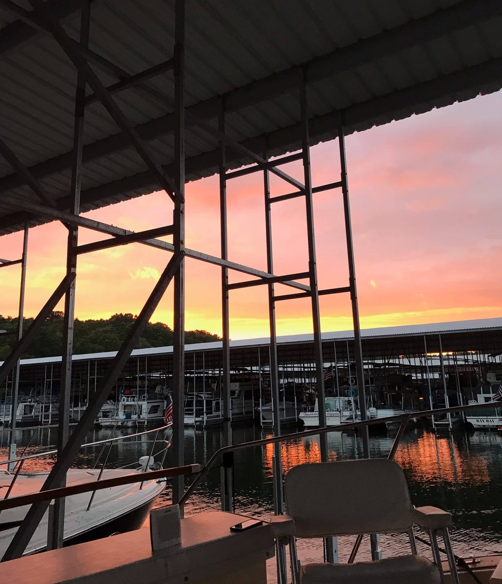 A sunset over a marina with boats docked in it