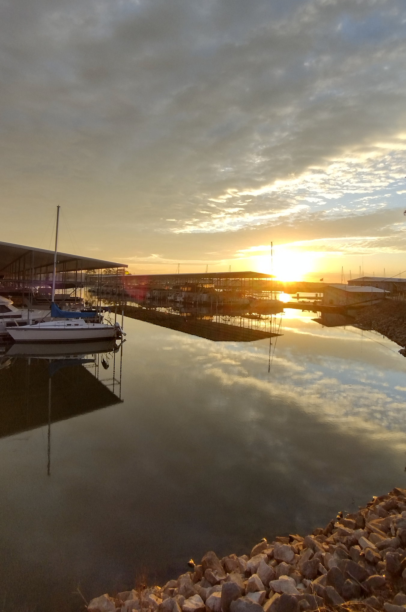 A sunset over a body of water with boats in it