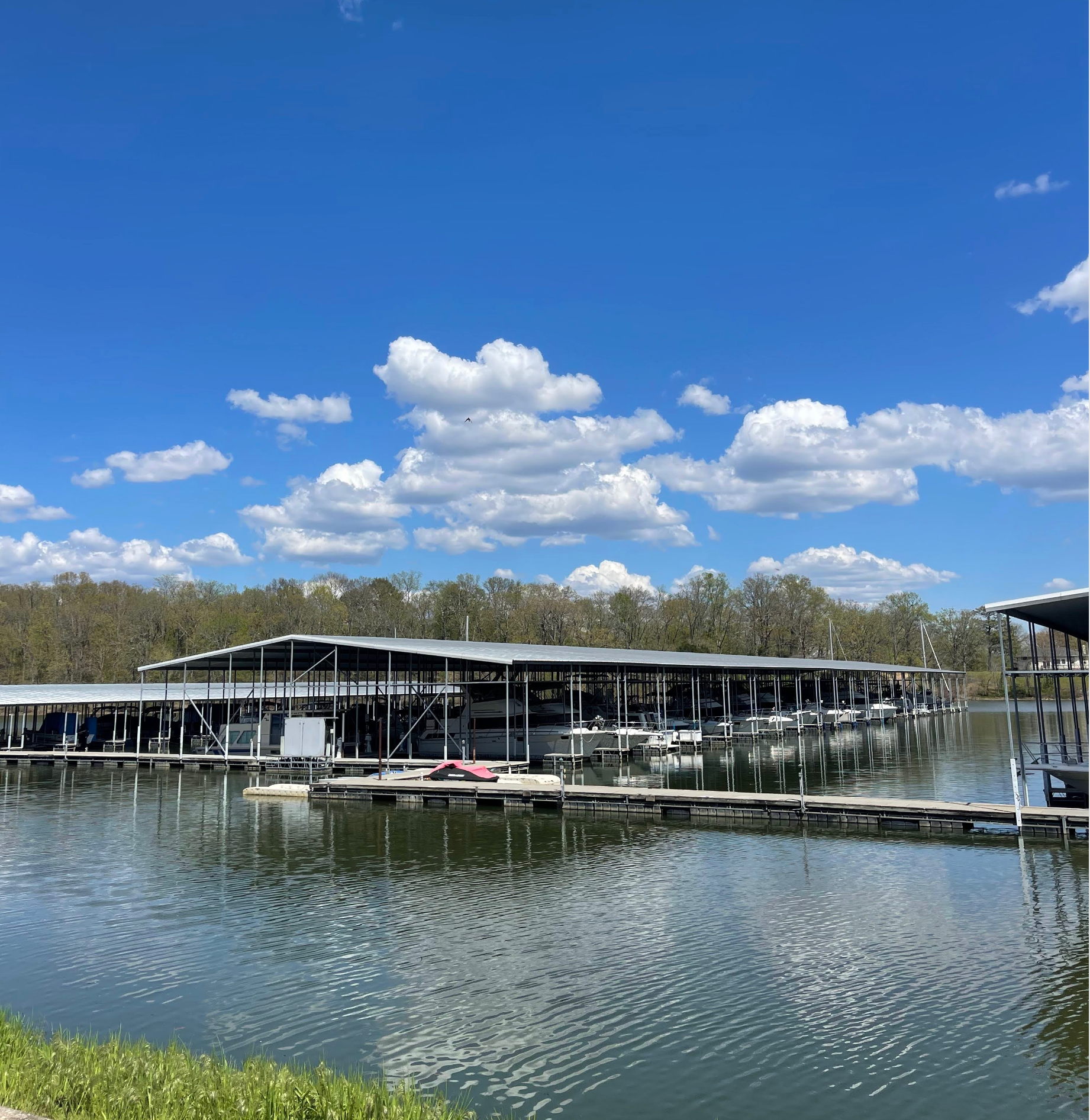A lot of boats are docked at a marina on a sunny day