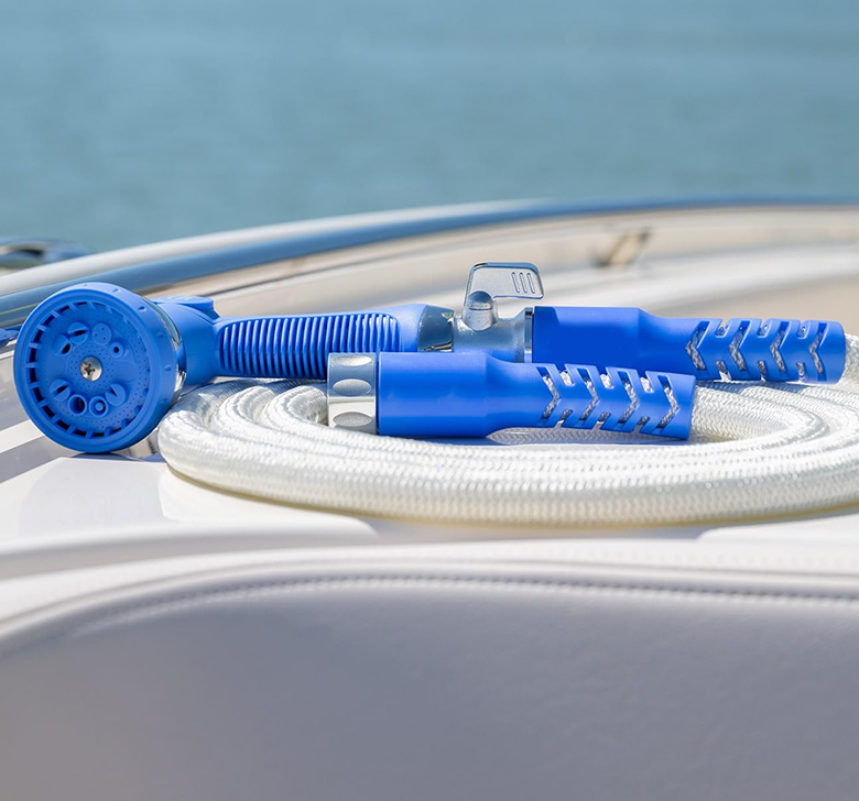 A blue hose is laying on top of a white hose on a boat.