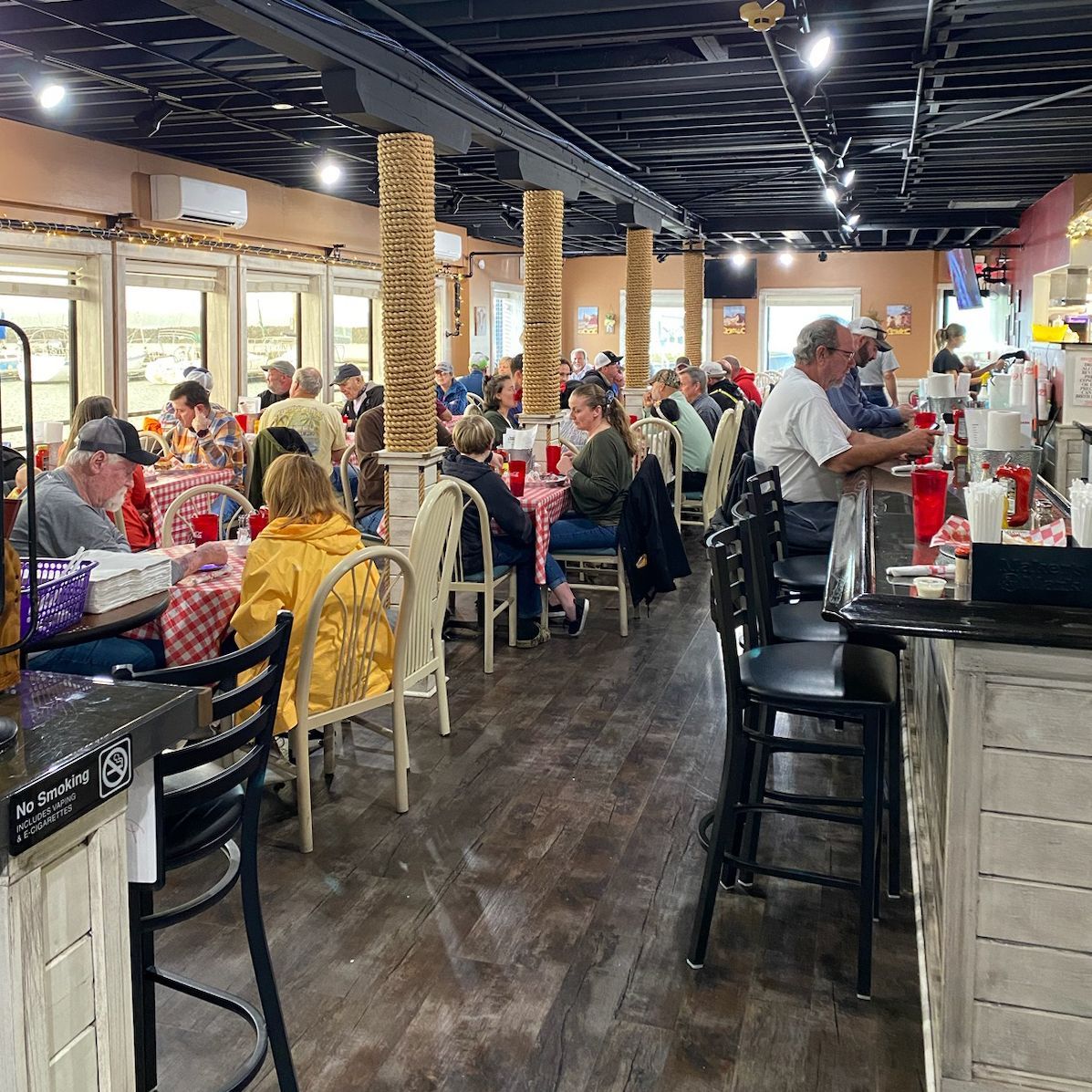 A group of people are sitting at tables in a restaurant.