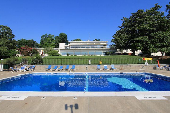 A large swimming pool with a large building in the background