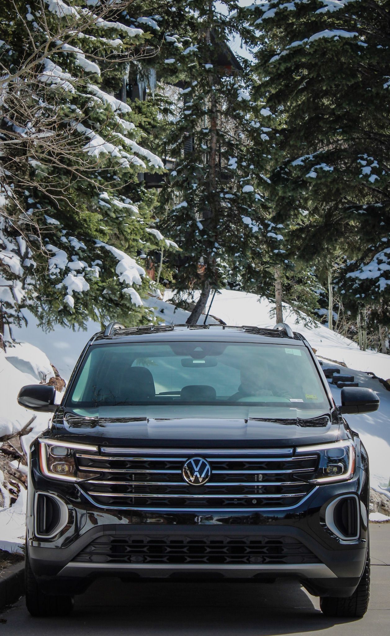 A volkswagen atlas is parked in a parking lot in the snow.