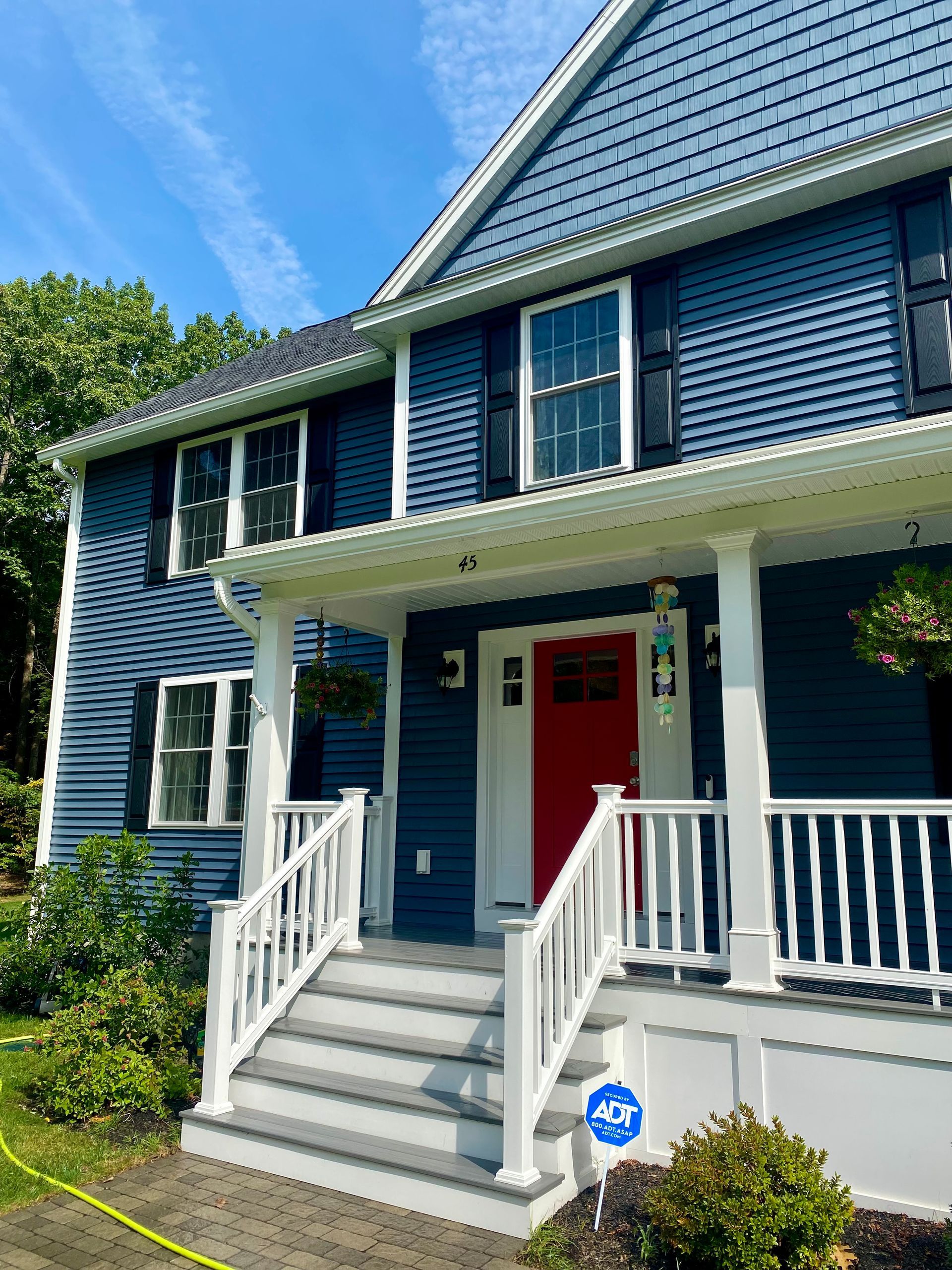 A person is cleaning a house with a high pressure washer.