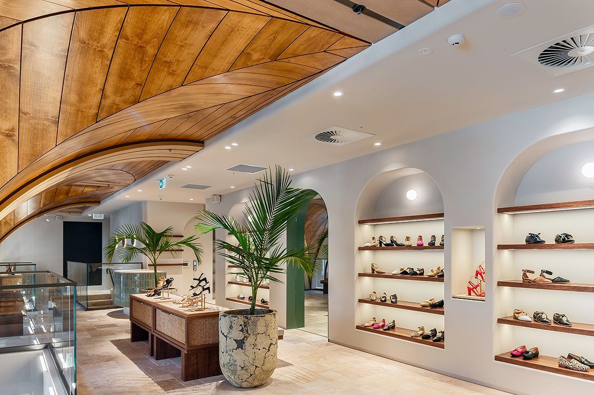 Interior of a store with wooden ceiling, white walls, and displays of merchandise.