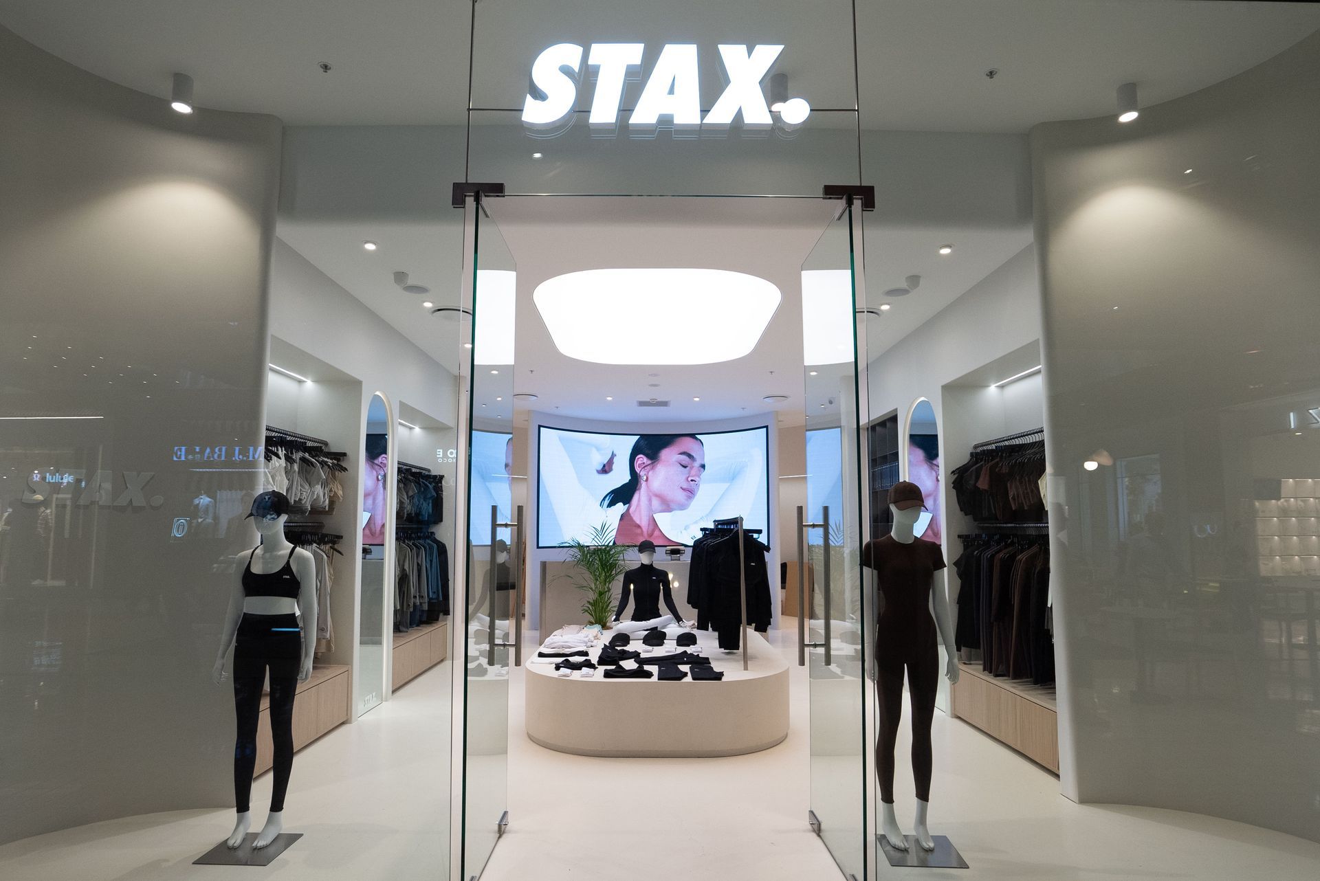 Entrance to a STAX. store with mannequins in activewear and a central display.