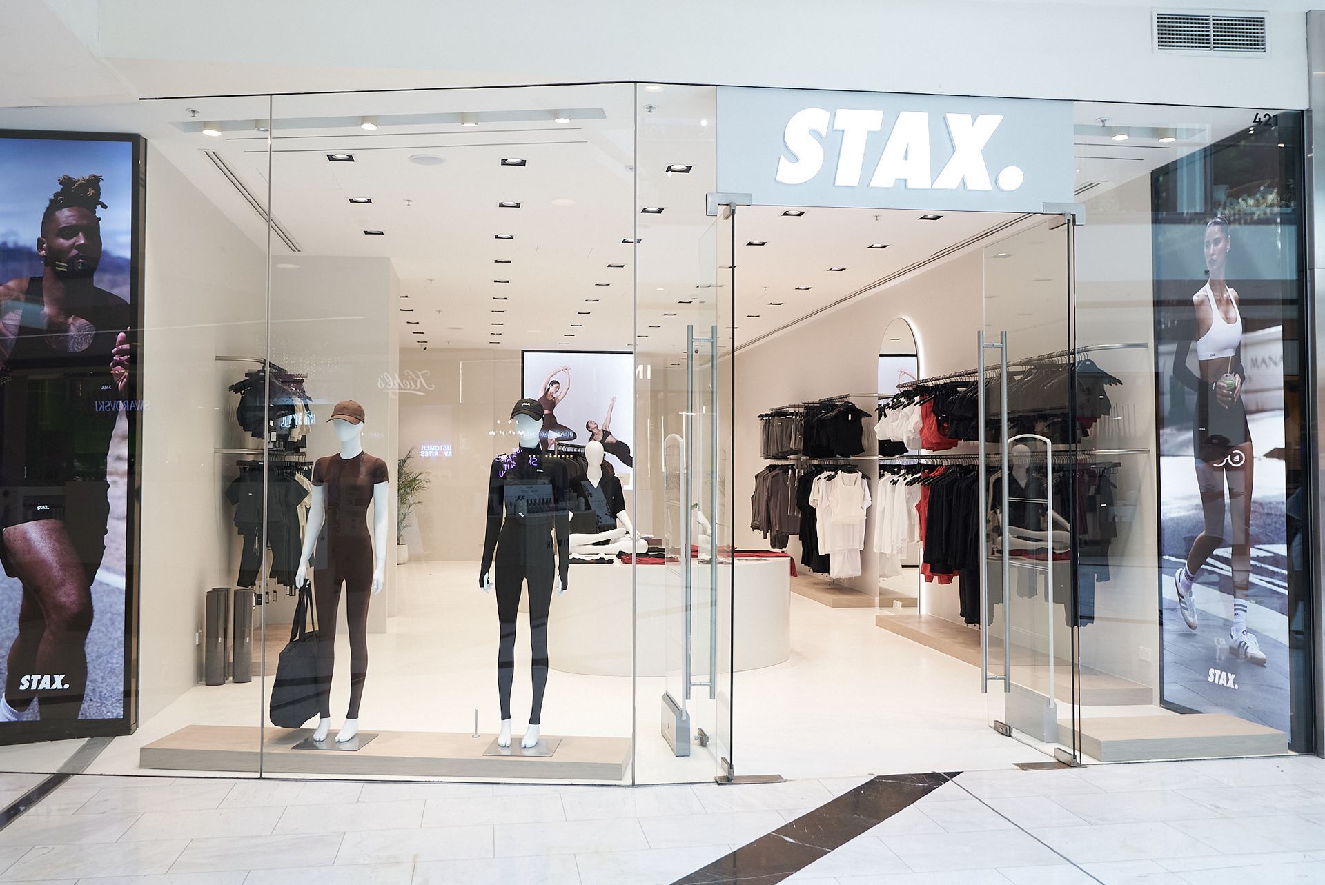 STAX. store front with glass doors, mannequins, and clothing displays.