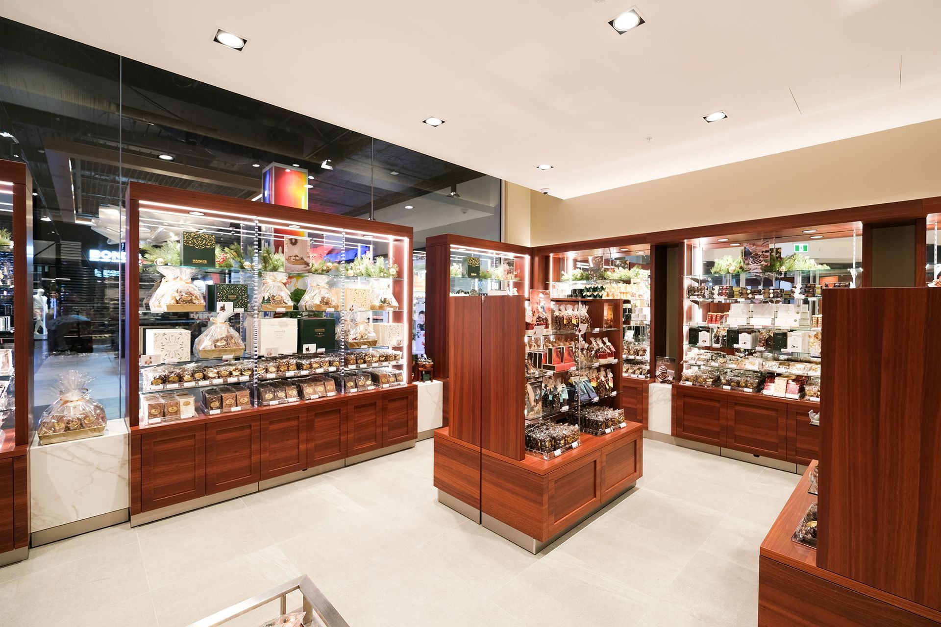 Interior of a brightly lit electronics store with display tables and product demonstrations.