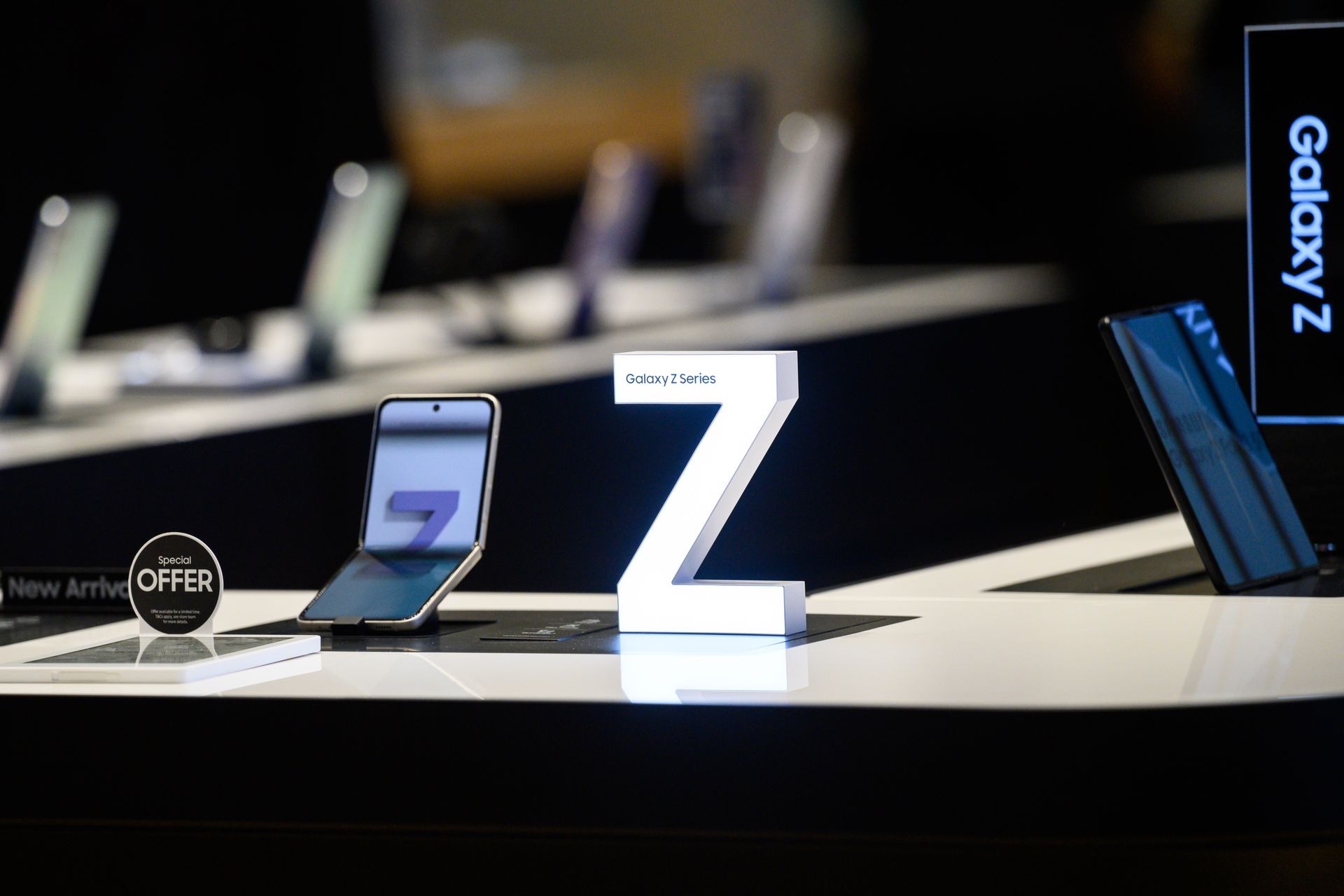 Samsung Galaxy Z foldable phones on display with a large white “Z” logo.
