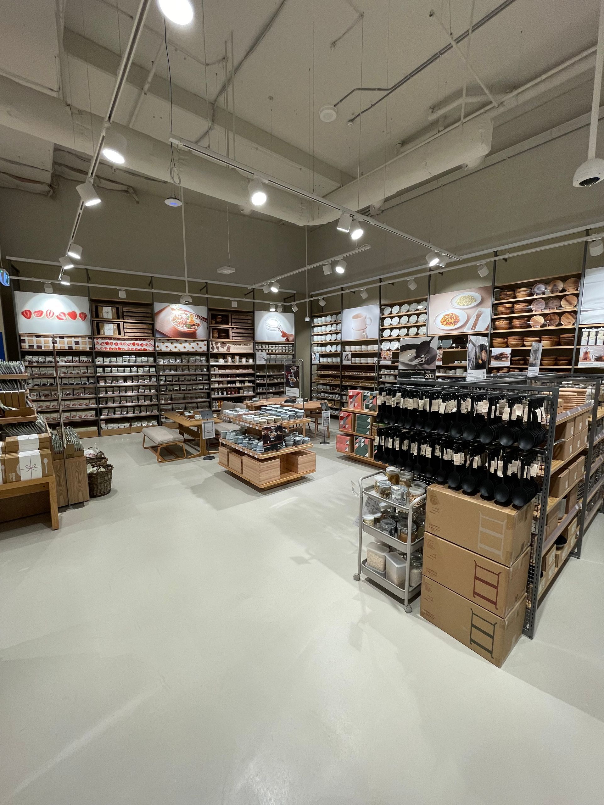 Interior shot of a well-lit retail store with wooden shelves displaying various items, including boxes and products.