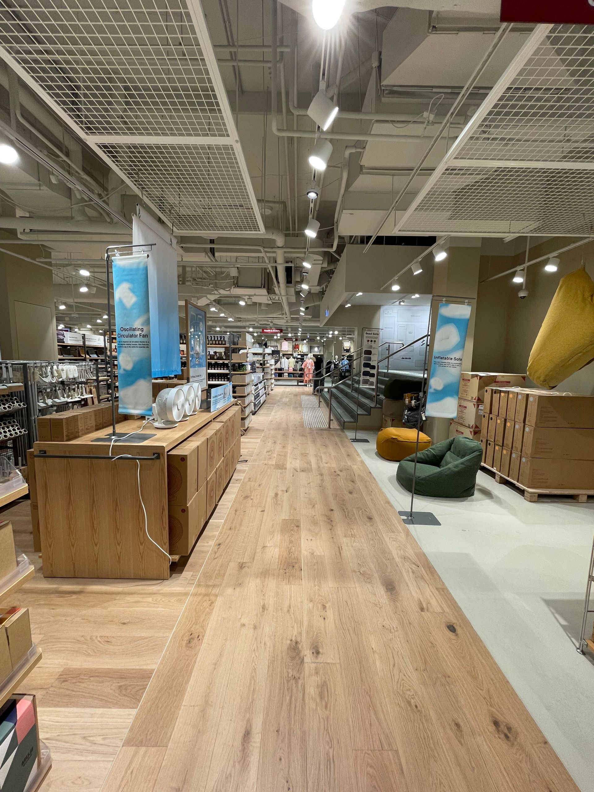 Long wooden hallway in a store with shelving, wooden counters, and a green beanbag chair.