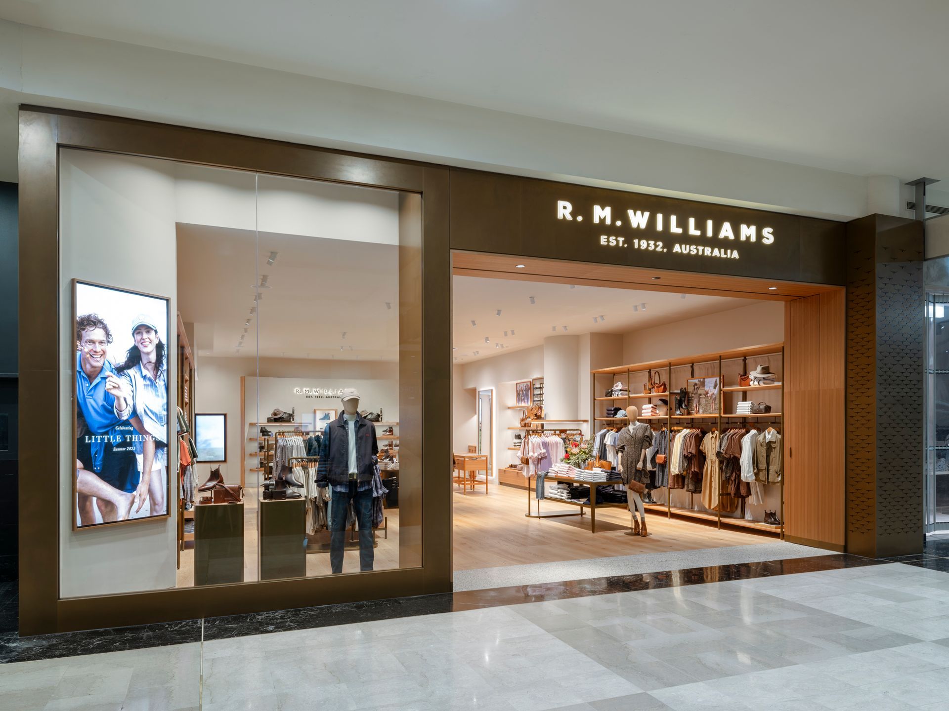 R.M.Williams store entrance, featuring display of clothing, mannequins, and signage, in a mall setting.