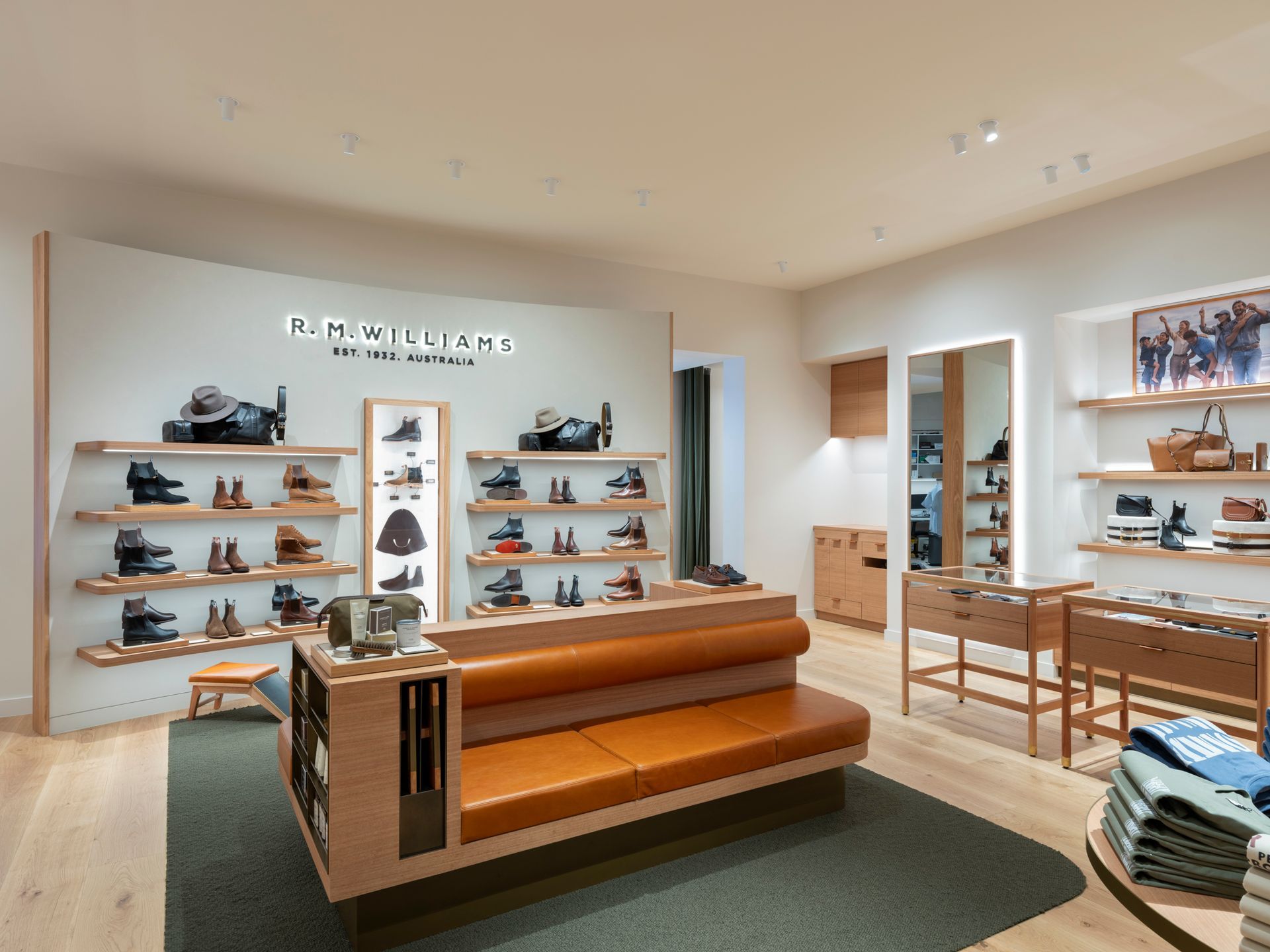 Shoe store interior with leather bench and shelves displaying shoes. Warm wood tones and neutral walls.