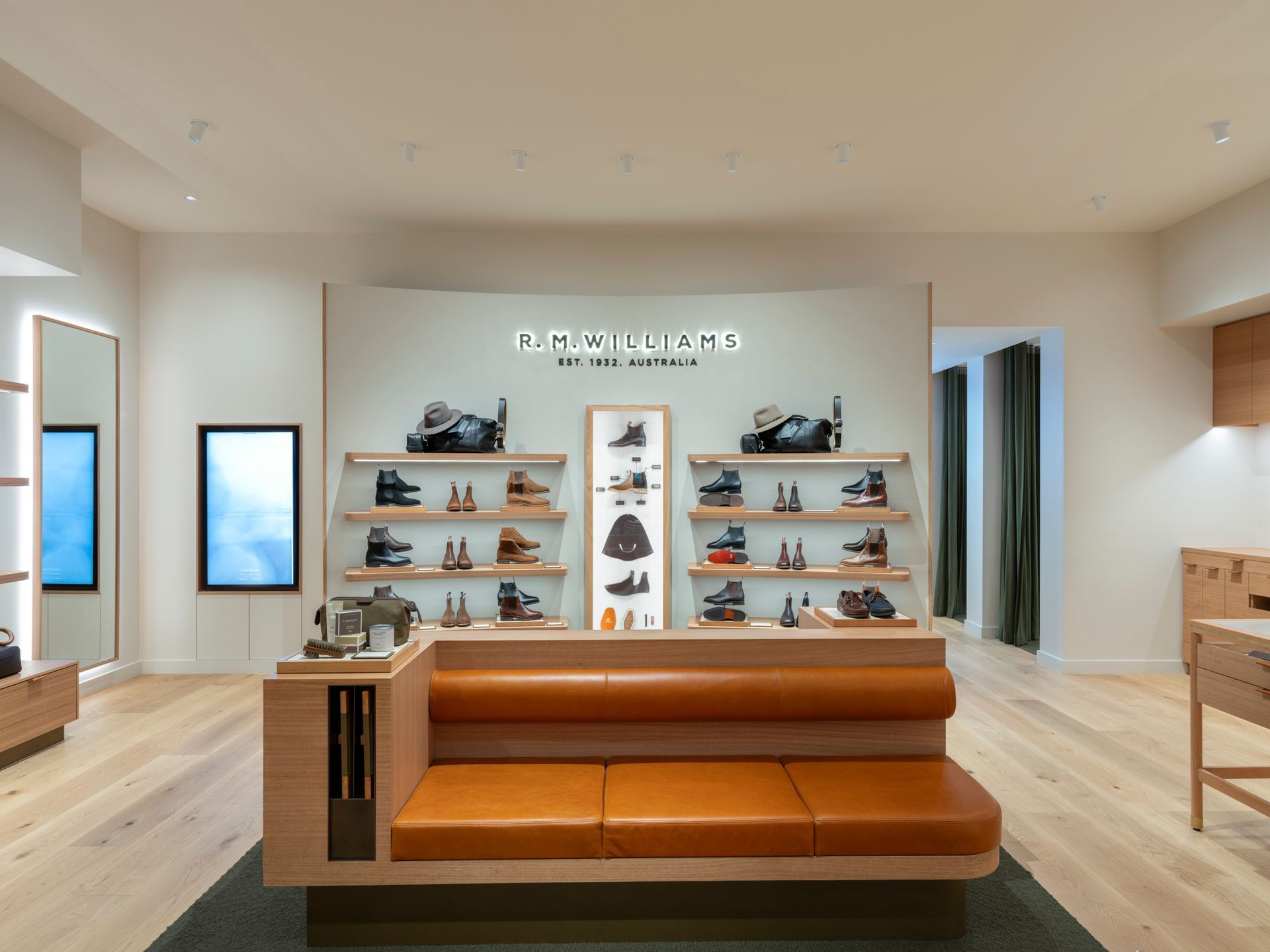 Shoe store interior with leather sofa, shelves displaying footwear, and a neutral color scheme.