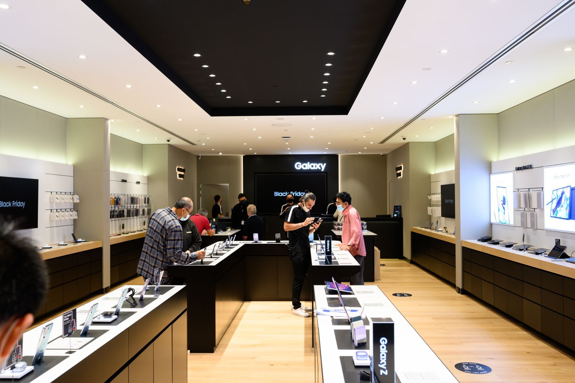 Three folded Samsung Galaxy Z Flip phones in purple, cream, and teal, on a table.