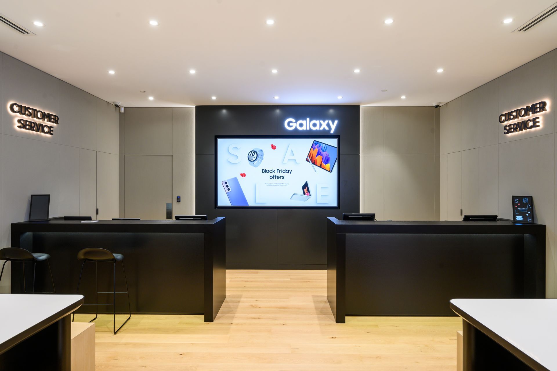 Samsung store interior with customer service counters, a large display screen, and the 