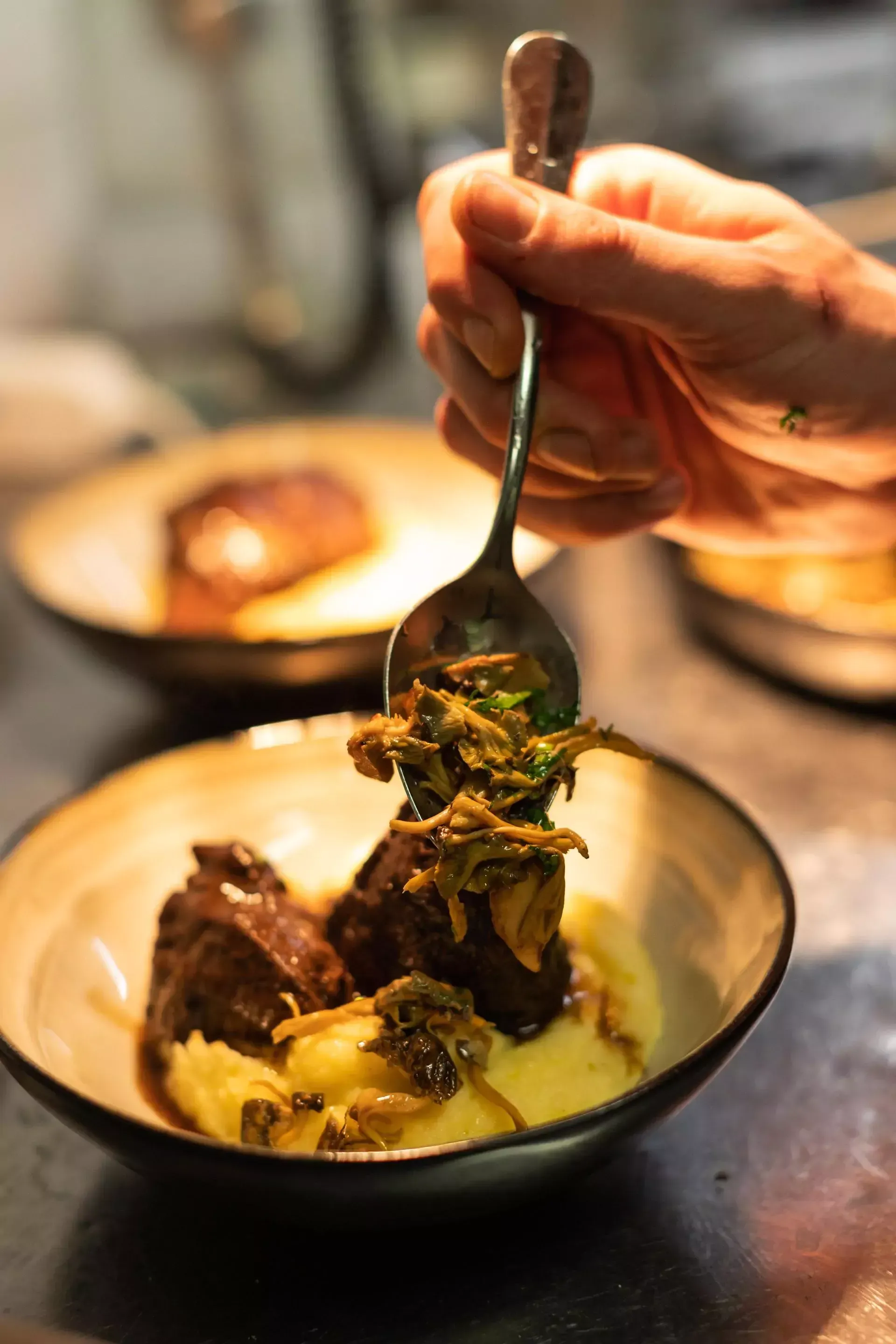 Une personne tient une cuillère au-dessus d'un bol de nourriture.