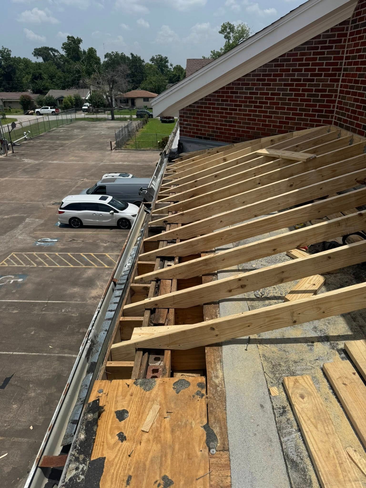 The roof of a building is being repaired with wooden beams.