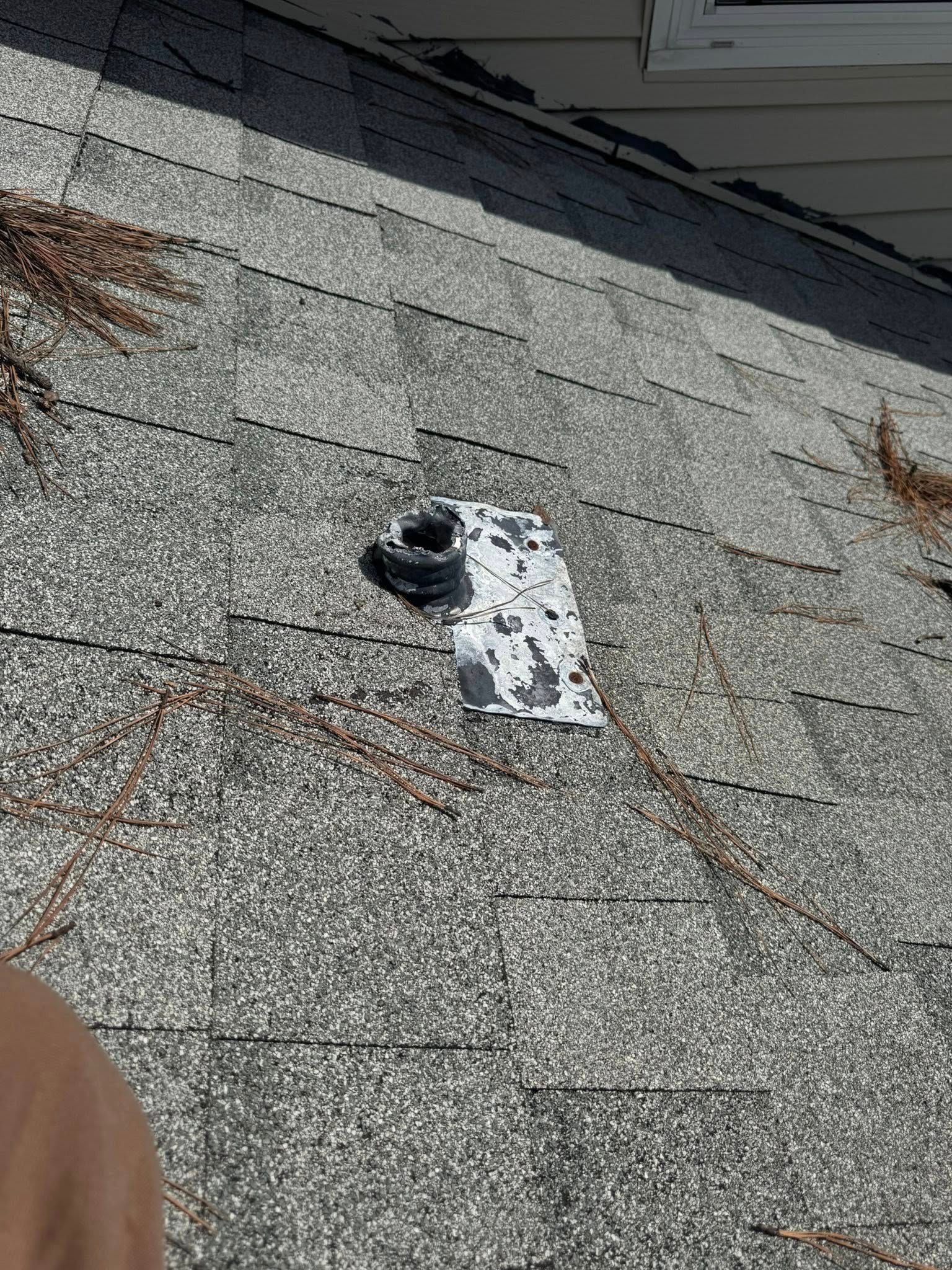 A person is standing on a roof with a piece of paper on it.