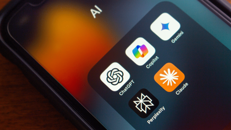 Smartphone screen with AI app icons: ChatGPT, Copilot, Gemini, Claude, and Perplexity.