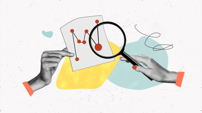 Hands holding a chart and magnifying glass analyzing data.