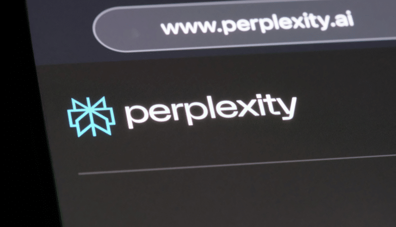 Perplexity website logo and address bar displayed on a dark screen. The logo is blue, with the word 