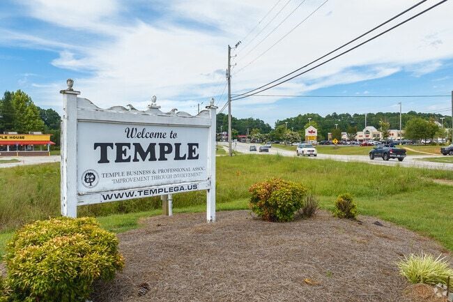 Tall, weathered sign for the Sewell Coco theater with a clock face.