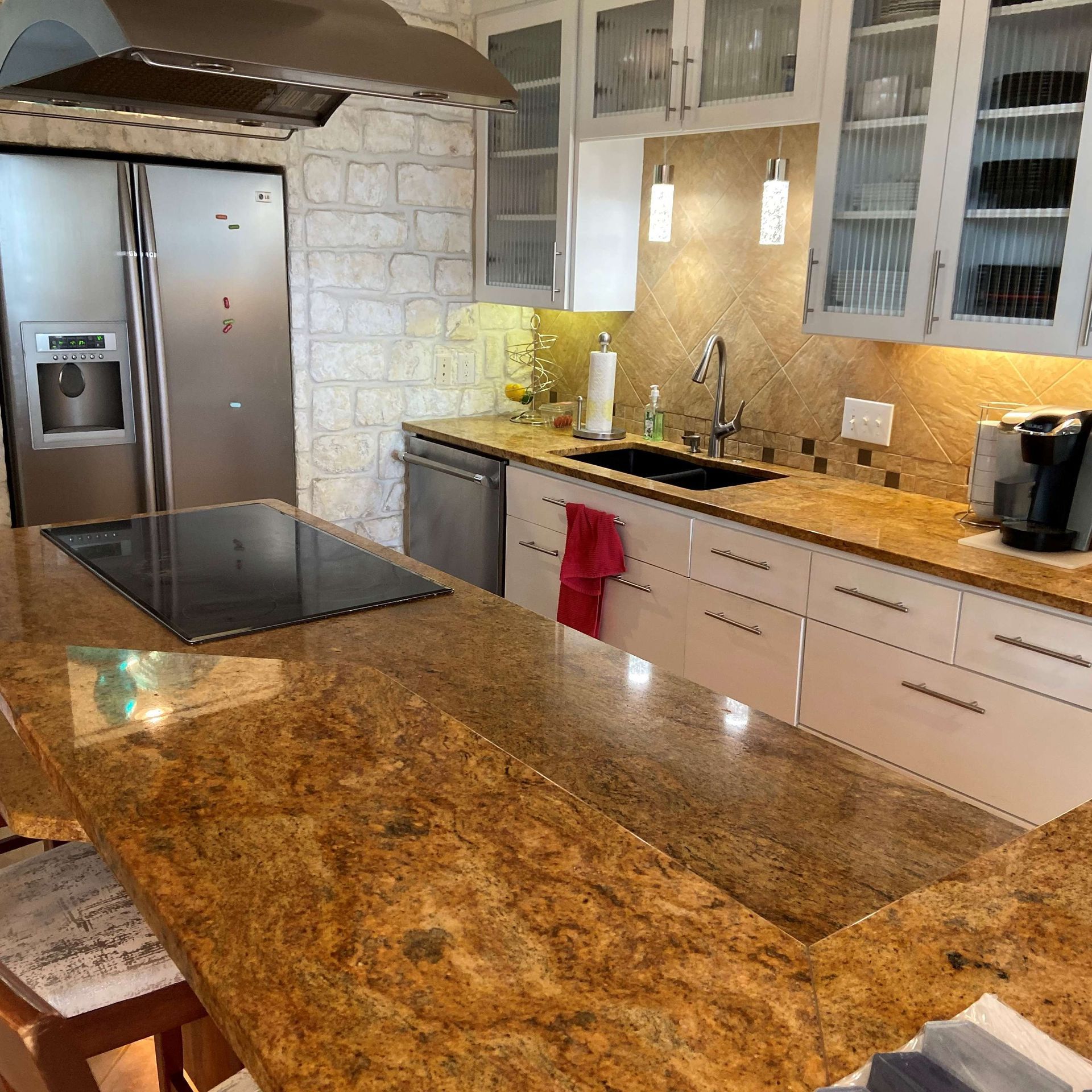 Modern kitchen with granite countertops, white cabinets, and stainless steel appliances.