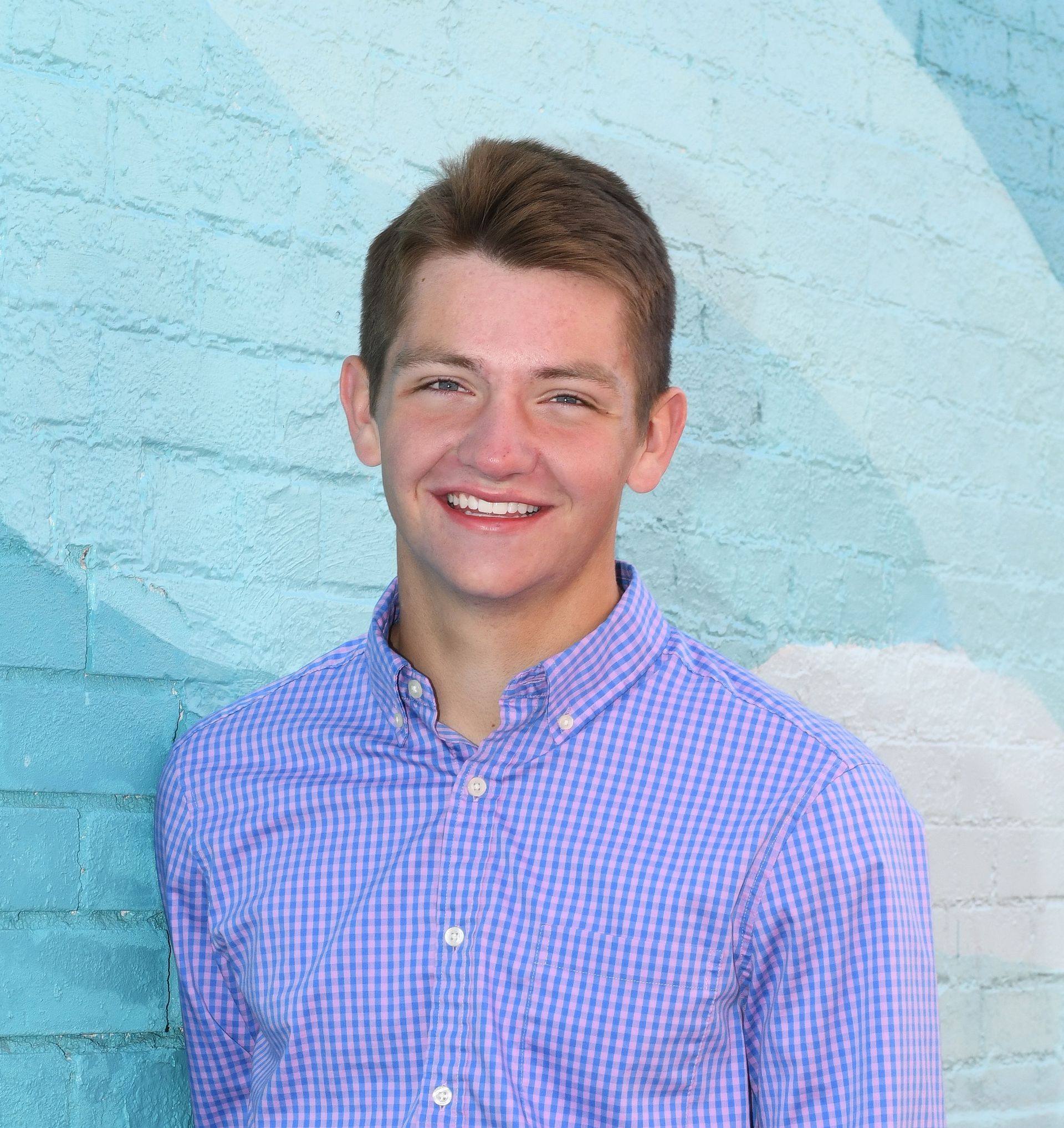 A woman in a red shirt is smiling for the camera.