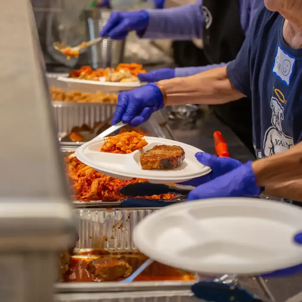 A man wearing a mask is cleaning a table with a mop