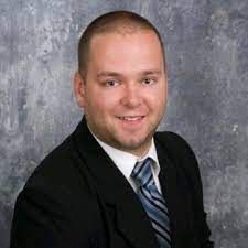 A man in a suit and tie is smiling for the camera.