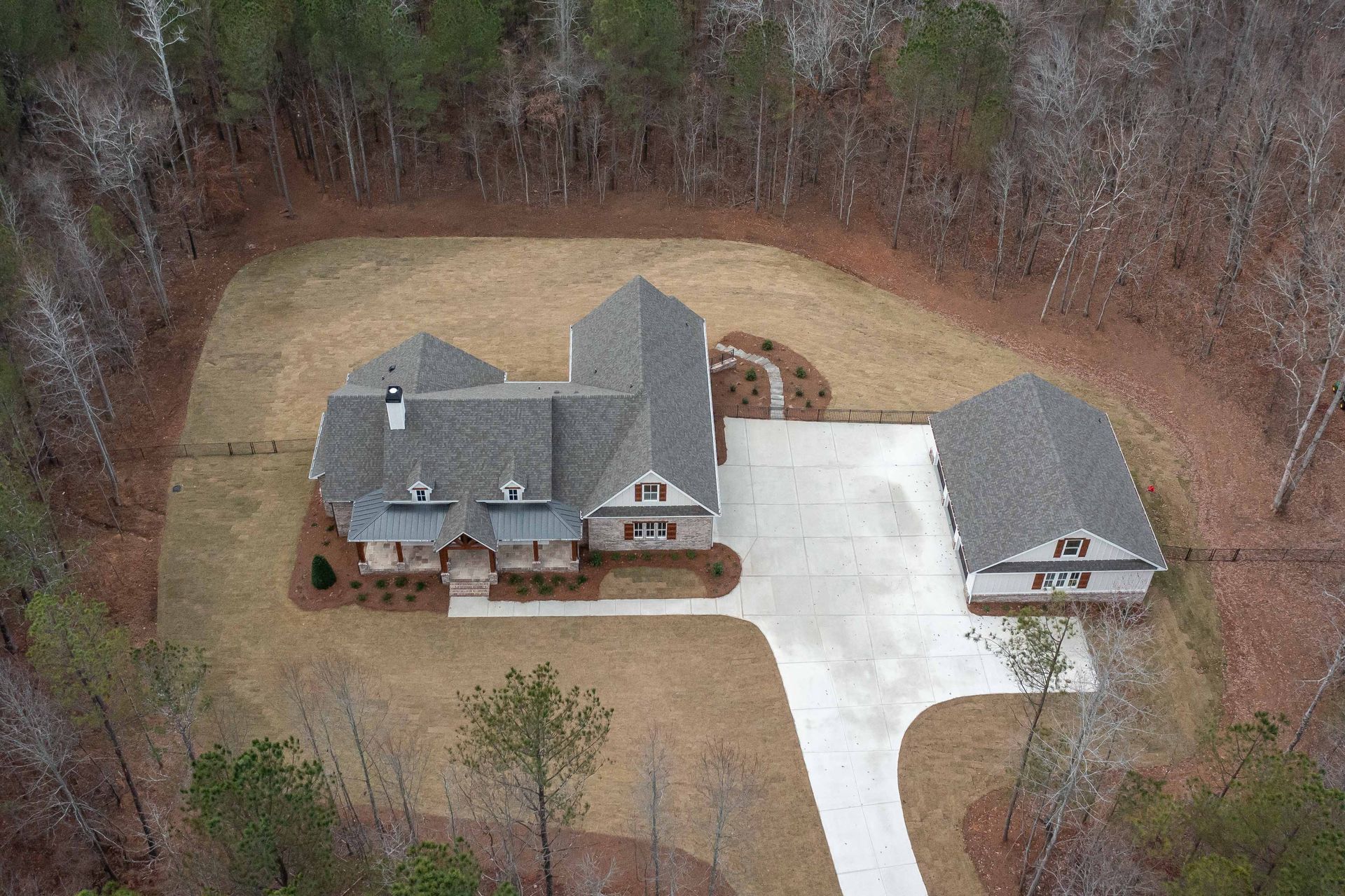 An aerial view of a house in the middle of a forest