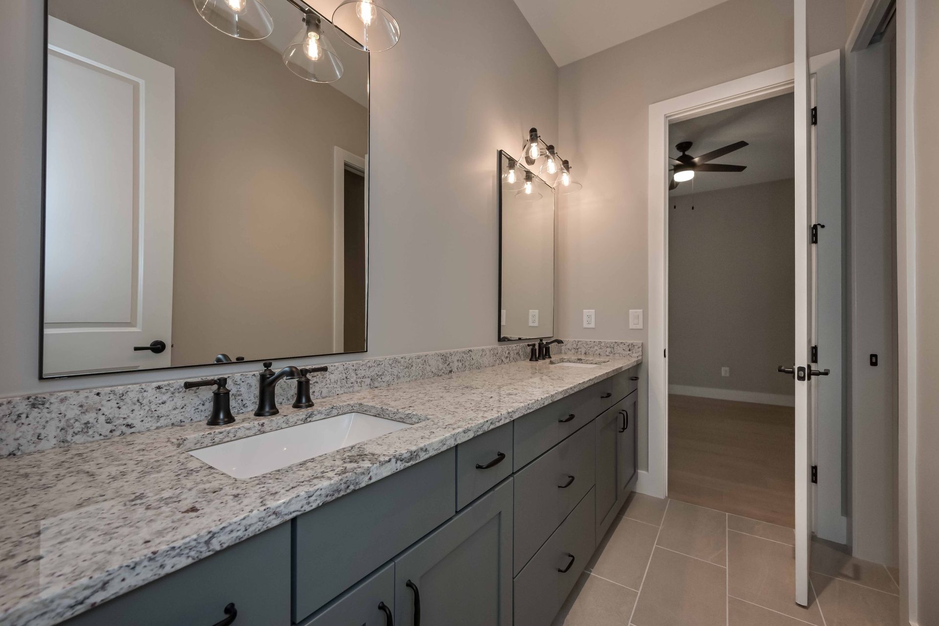 A bathroom with two sinks , a mirror and a ceiling fan.